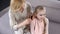 Caring mature mother combing daughters blond hair, beauty time, relationship