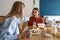 Caring mom gentle touch head teen girl sitting at table on morning breakfast. Trusting relationship