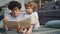 Caring mom reading book to small curious boy relaxing on floor in light house