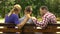 Caring mother and dad supporting sad teen son sitting on bench in park, crisis