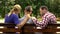 Caring mother and dad supporting sad teen son sitting on bench in park, crisis