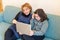 Caring mother helps her daughter to do her homework during quarantine, home schooling using modern technology, use of laptop for