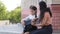 Caring mother hispanic woman mommy parent sits outdoors with beloved daughter schoolgirl helps little girl kid child