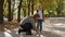 A caring mother ties her son`s shoelaces in the Park in the fall before school.