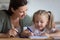 Caring mum help kid girl drawing picture with felt-tip pens
