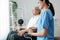 Caring nurse and a contented senior man in a wheel chair at home.