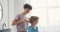 Caring parent brushing small boy`s hair with hairbrush in bathroom at home