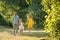 Caring parents holding hands of daughter while walking together in the park