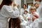 A caring positive experience. Parents and two kids in white bathrobes having morning routine in hotel bathroom, brushing