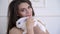 Caring pregnant woman 40 years old plays with a little white hare in her house. close up