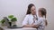 Caring professional woman pediatrician playing with small child in the office. A small child is examined by pediatrician