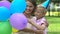 Caring son congratulates mom on birthday, presenting colored balloons, joy time