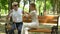 Caring woman assisting visually impaired pensioner to sit on bench, support