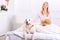 Caring woman lying on bed with her dog