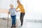 Caring young woman helping her aged granny to stand up