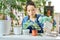 Caring young woman spraying replanted plants using a spray bottle while watering houseplants at home