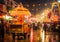 a carnival with a cart and a carousel in the rain at night time with people walking around