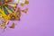 Carnival or mardi gras concept with golden carnival masks and party decorations on purple background. Top view, flat lay
