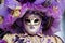 Carnival purple-beige-gold mask and costume at the traditional festival in Venice, Italy