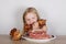 Carnivore keto diet concept - little blond girl eating raw meat