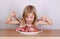 Carnivore keto diet concept - little blond girl eating raw meat