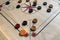 Carom board with striker, carom men, and queen.