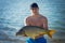 Carp fishing. Young fisherman holding a big common carp in lake. Close up portrait.