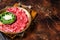 Carpaccio Beef meat appetizer with parmesan and arugula. Dark background. Top view. Copy space