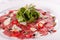 Carpaccio , beef steak salad. Summer launch, healthy eating concept. white plate with sauce. salad served in italian