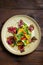 carpaccio plate on dark wooden table top view