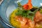 Carpaccio salmon fillet with shiso leaves in a blue bowl