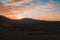 Carpathian meadow and beautiful sunset in the mountains - spring landscape, spruces on the hills, dark cloudy sky and bright