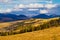 Carpathian Mountains in Transcarpathia, late evening sun in valley, mountains in early spring, white heavy clouds make shadows