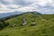 Carpathian sight of highland field with old wooden shepherds huts in the meadow on hill sides and mountains