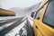 Carpathians, Ukraine - December 2019: yellow camper van driving on the snowy dirt road with winter forest on background