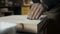 A carpenter applies a putty to a loft-style chair made of wood.