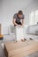 Carpenter assembling furniture service. Portrait of worker assembling kitchen drawer with tools. Full length