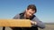 Carpenter with a beard and mustache against a blue sky touches the surface of the table, made by him by hand. handmade