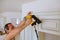 Carpenter brad using nail gun to Crown Moulding on kitchen cabinets framing trim,