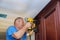 Carpenter brad using nail gun to Crown Moulding on kitchen cabinets framing trim