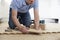 Carpenter Or Builder Laying New Oak Wood Block Parquet Floor In Kitchen At Home