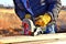 Carpenter with circular saw, cutting boards on site