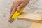 The carpenter cleans and grinds by hand with a bar with sandpaper wooden boards, close-up.