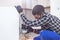 A carpenter with a corded jigsaw cutting a part of the wooden surface board