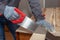 A carpenter cuts a board in half with a hand saw