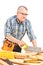 Carpenter cutting wooden batten with a saw