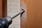 Carpenter drills hole for latch in new door