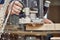 Carpenter with hand electric router machine at work. Milling process of acrylic kitchen countertop