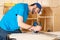 Carpenter with hand wood router machine at work. closeup of routing  slot into plank of pine woodworking construction tool concept