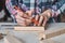 Carpenter hands taking measurement with a pencil of wooden plank. Concept of DIY woodwork and furniture making